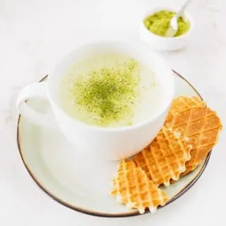 A large cup of Matcha Green Tea Latte served with cookies.