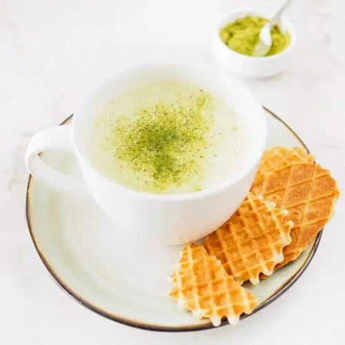 A large cup of Matcha Green Tea Latte served with cookies.