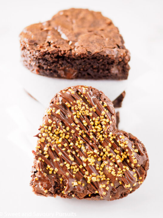 Close-up of heart shaped Chocolate Spiced Brownies with chocolate drizzle and gold sprinkles.