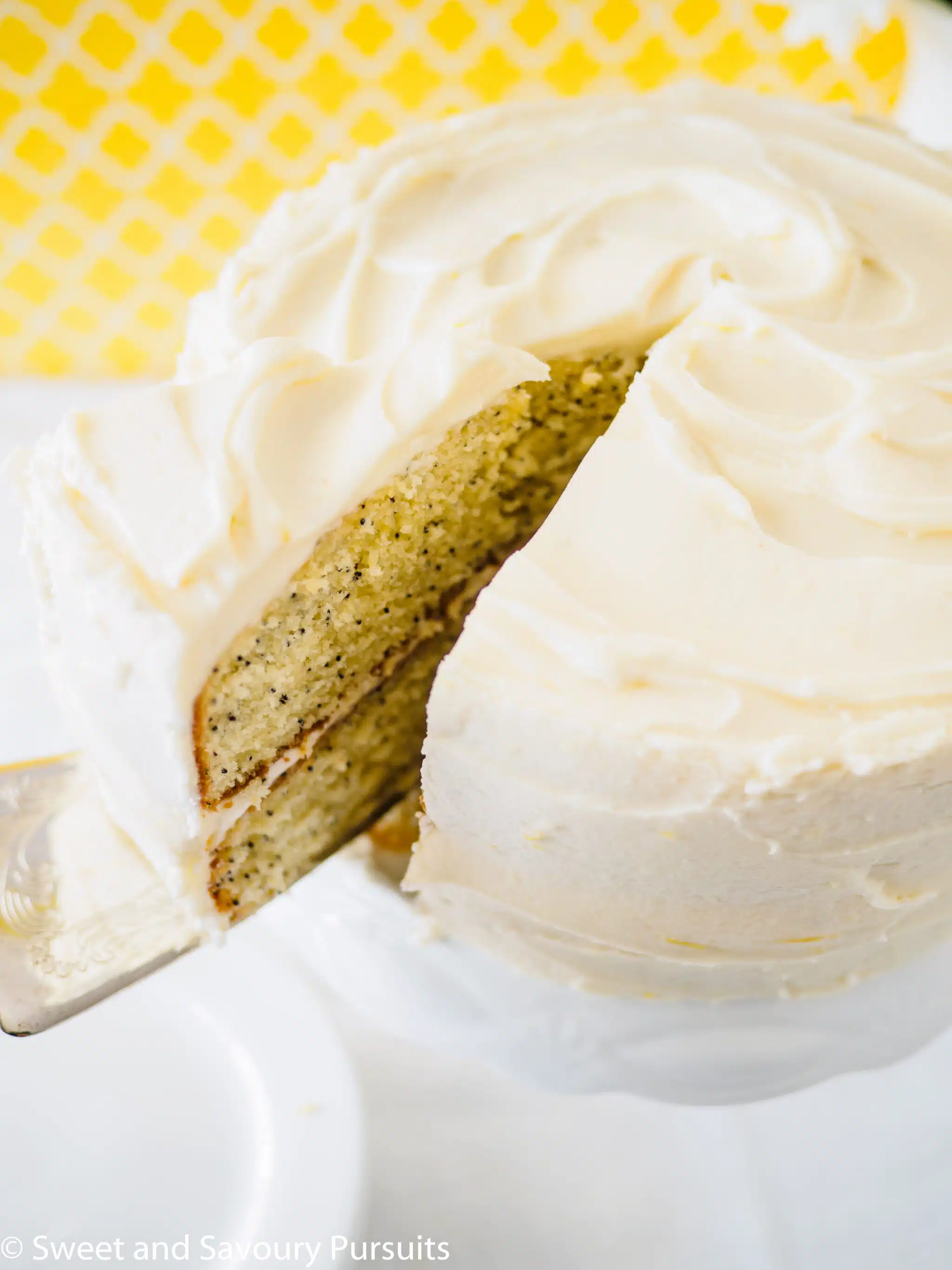 A close-up of a lemon flavoured cake with cream cheese frosting.