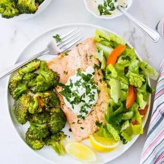 A serving of Baked Rainbow Trout Fillets with Roasted Broccoli on dish.