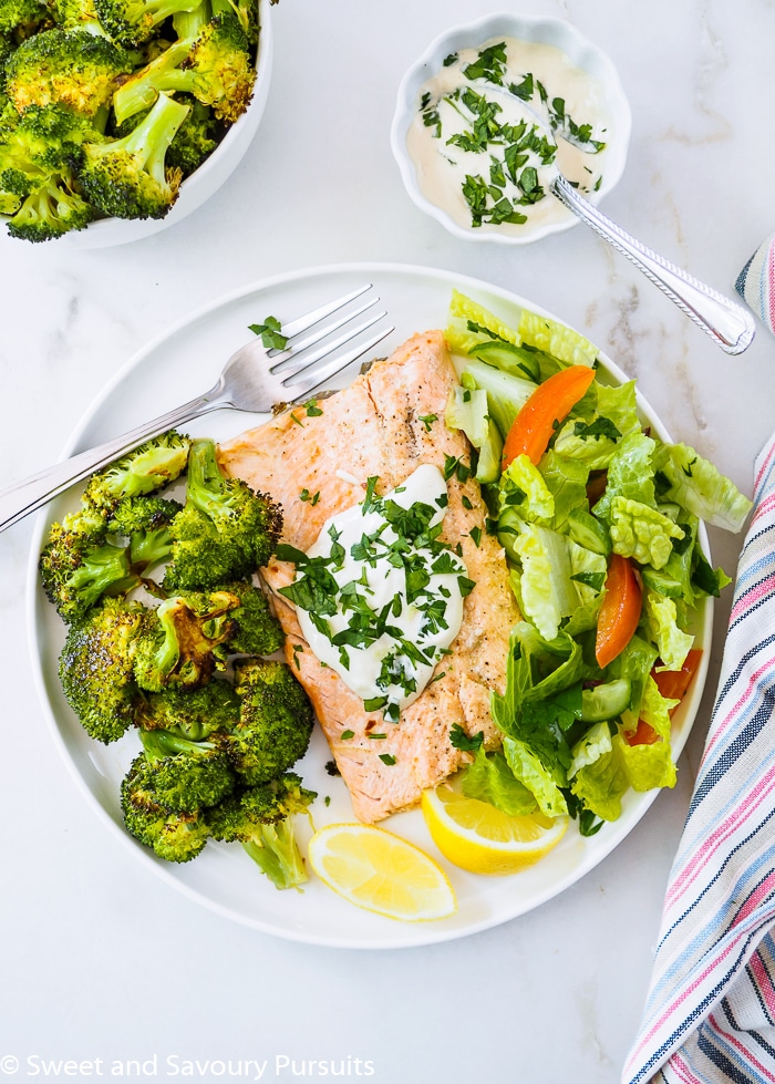 A serving of Baked Rainbow Trout Fillets with Roasted Broccoli on dish.