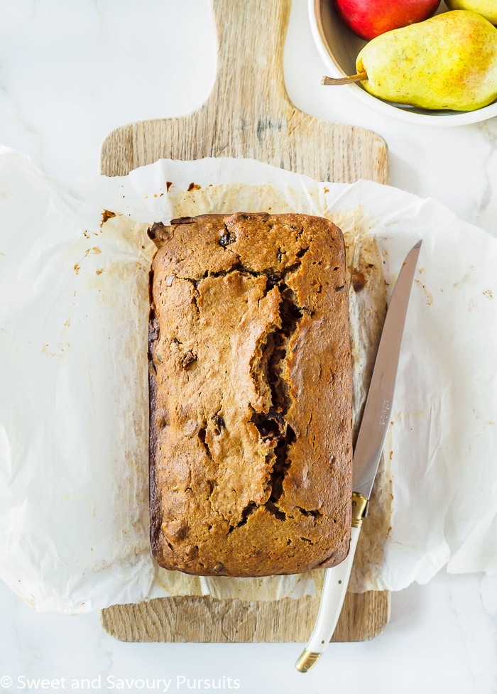 Top view of Pear, Date and Walnut Loaf on wooden cutting board.