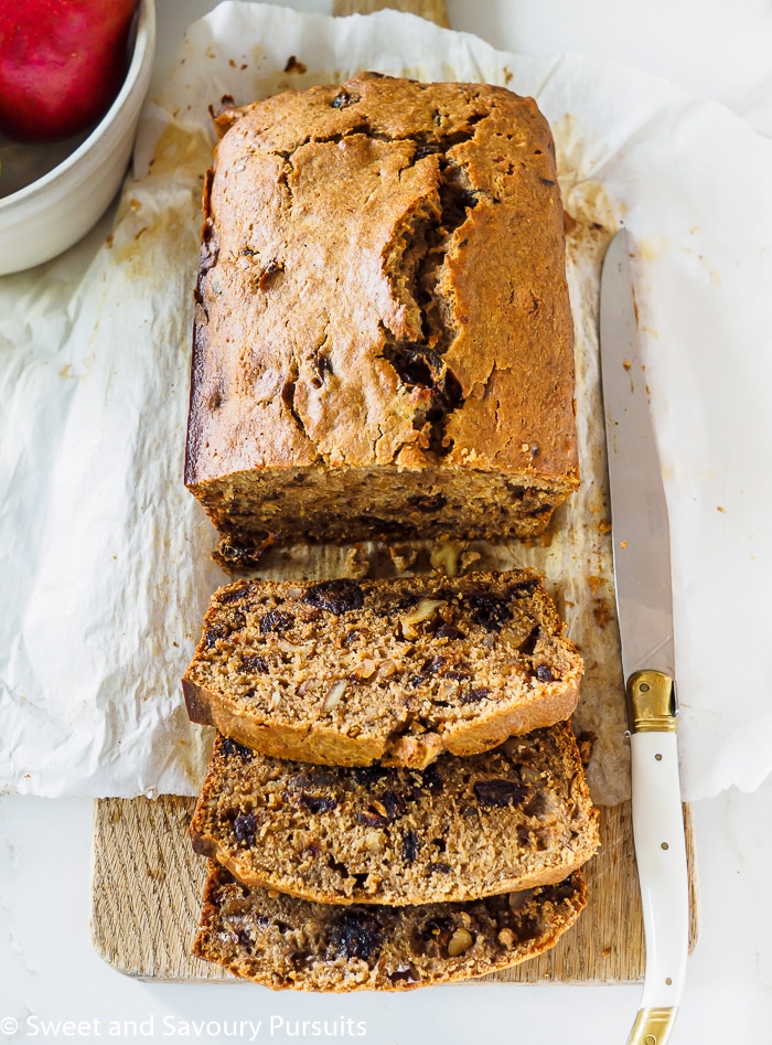 Sliced Pear, Date and Walnut Loaf cake on cutting board.