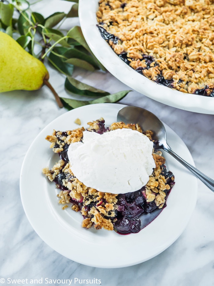 Pear and Blueberry Crumble served with vanilla ice cream.