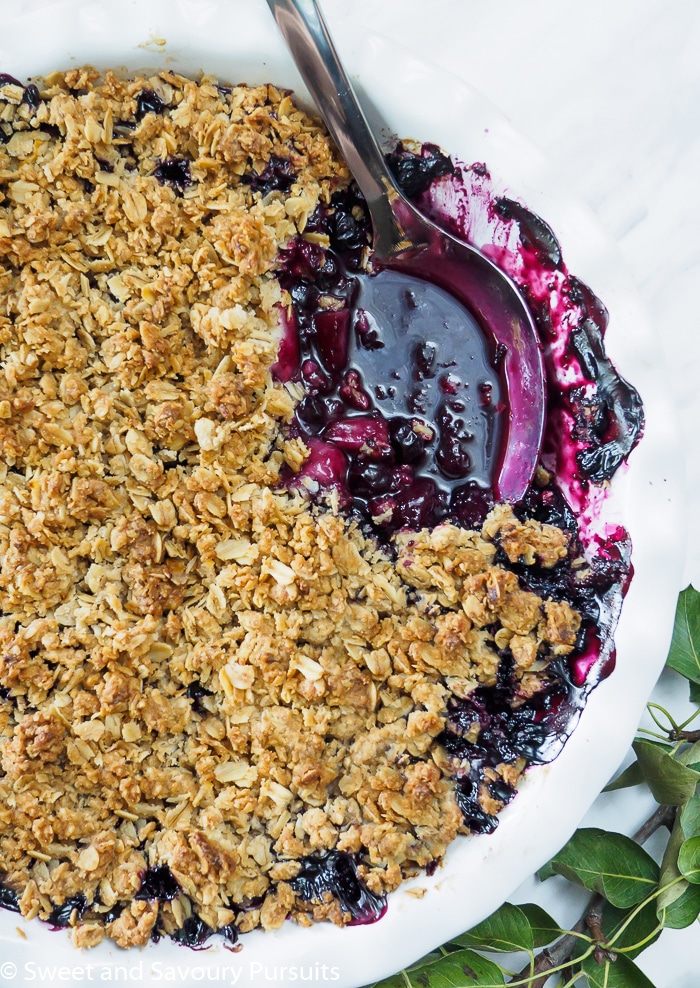 Blueberry and pear crumble with serving spoon. 