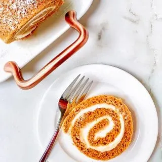 A slice of a rolled pumkin cake stuffed with a maple cream cheese swirl.