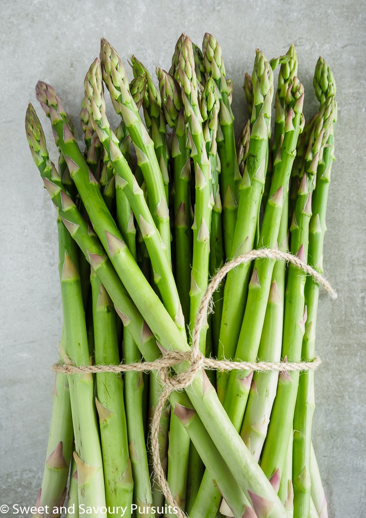 A bunch of fresh asparagus tied with kitchen twine.