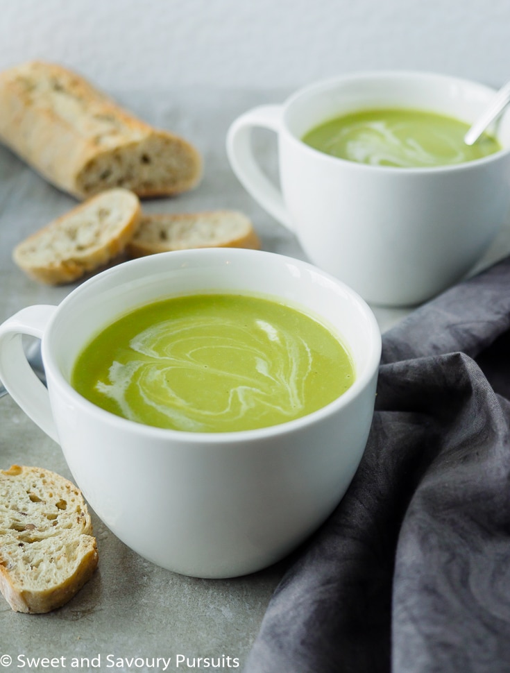 Two mugs of creamy asparagus soup.