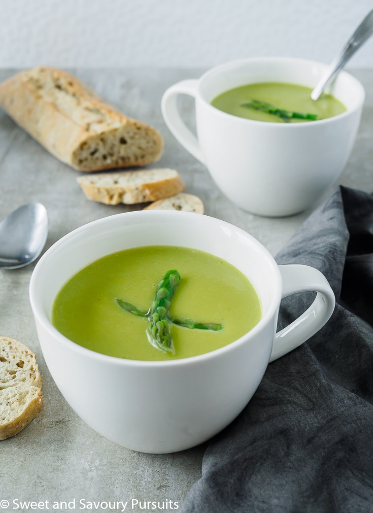 Creamy Asparagus Soup in white mugs.