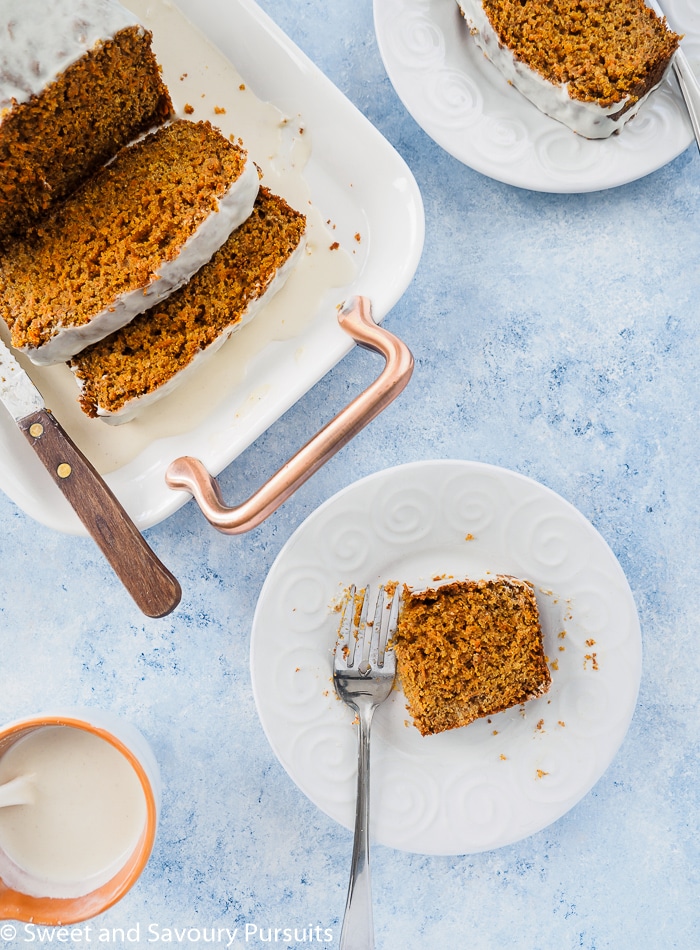 A dish with a partially eaten slice of carrot bread.