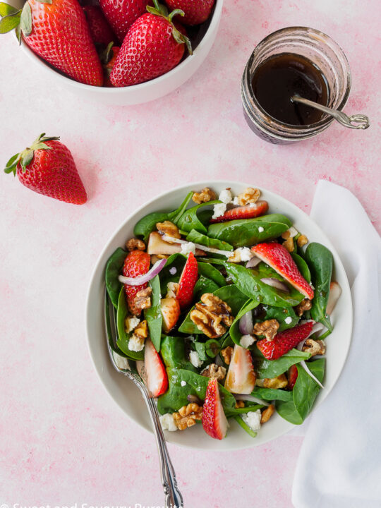 Bowl of a Strawberry Spinach Salad dressed with a balsamic vinaigrette.