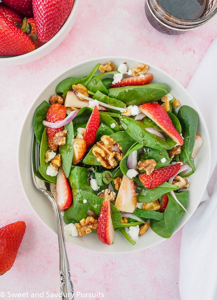 Top view of a plate of strawberry spinach salad.