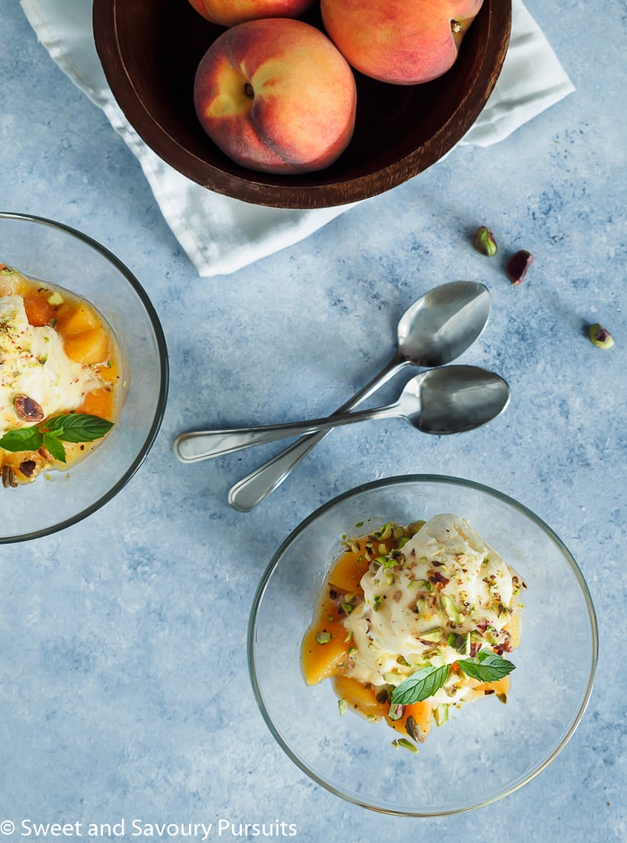 Bowl of ice cream topped with peach sauce.