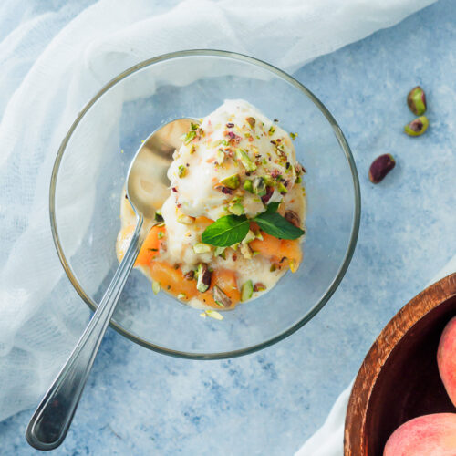 Fresh peach sauce on top of ice cream bowl.