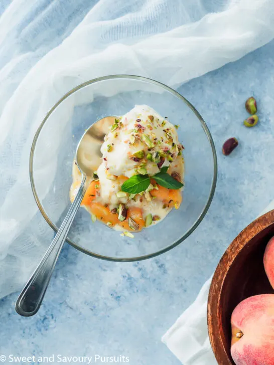 Fresh peach sauce on top of ice cream bowl.