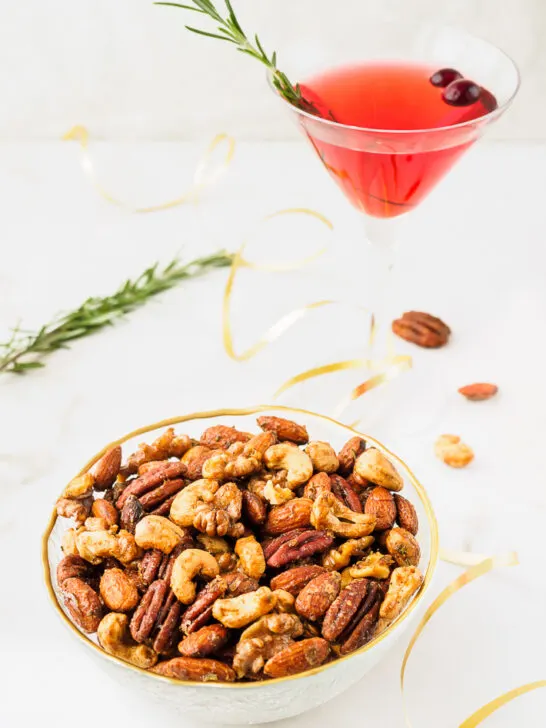 Bowl of seasoned nuts served with a cocktail.