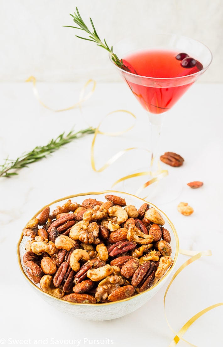 Bowl of seasoned nuts served with a cocktail.