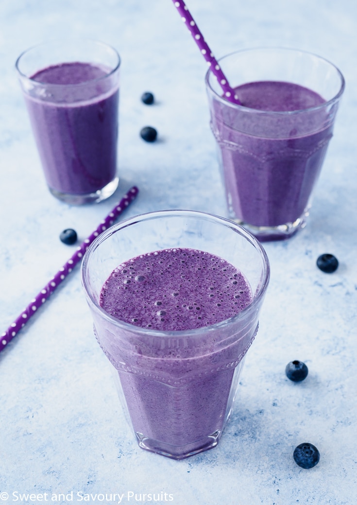 Blueberry Oatmeal Smoothie flavoured with coconut, cinnamon and nutmeg served in glasses.