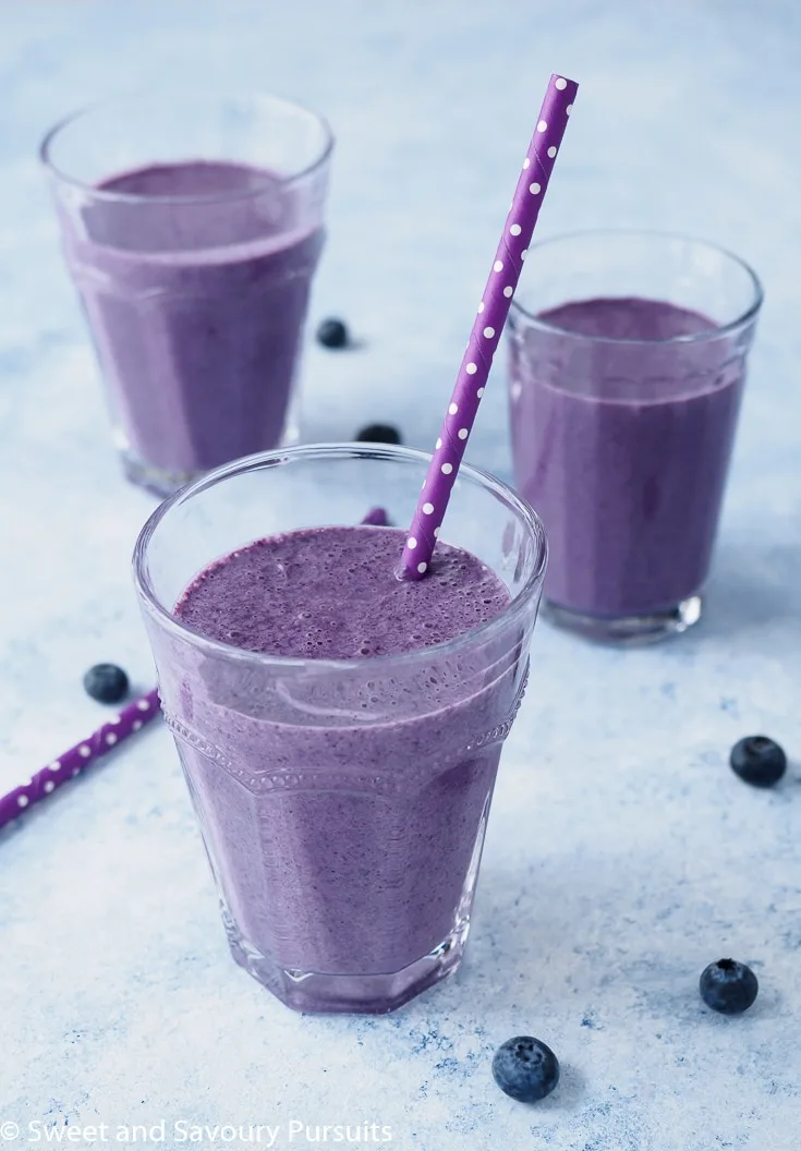 Blueberry Oatmeal Smoothie flavoured with coconut, cinnamon and nutmeg served in glasses.