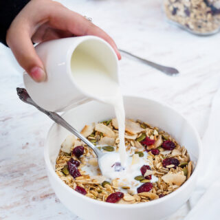 Bowl of homemade muesli being topped with milk.