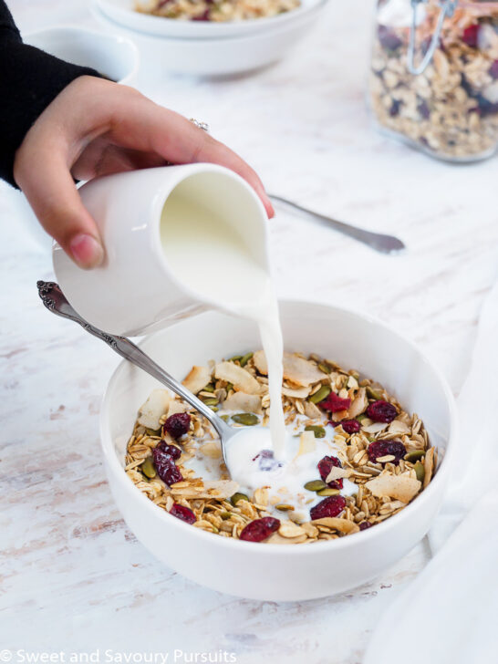 Bowl of homemade muesli being topped with milk.