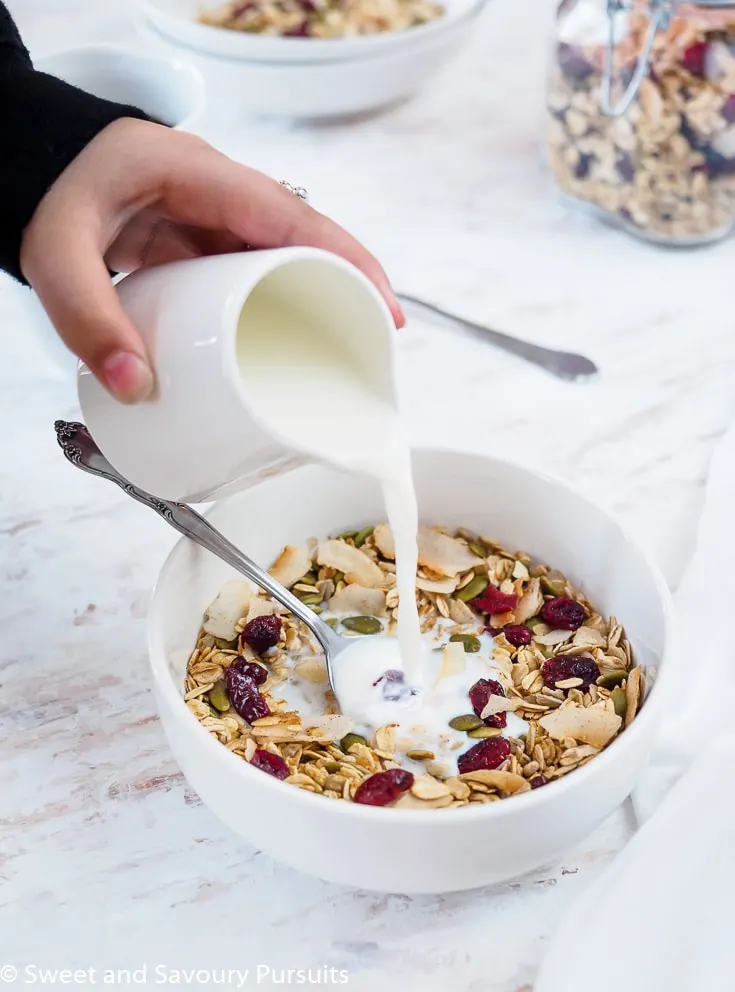 Bowl of homemade muesli being topped with milk.