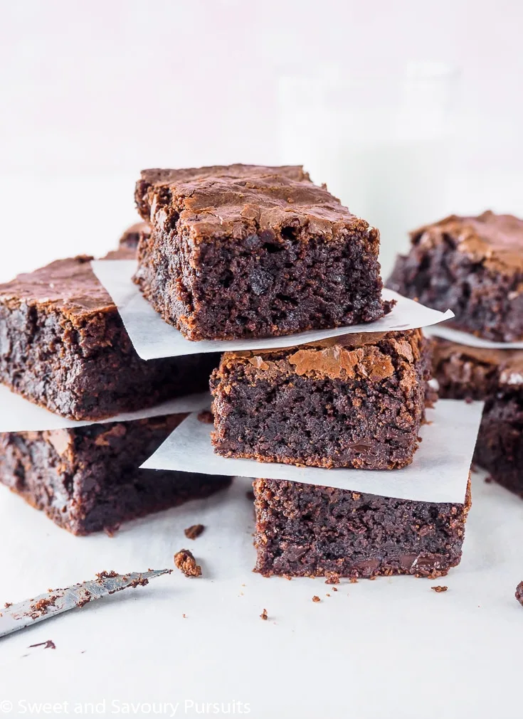 Sliced Gluten-Free Almond Flour Brownies on board with a glass of milk in the background.