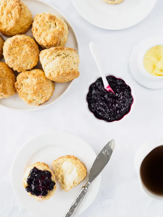 Dish of homemade Irish Scones served with butter and berry jam.