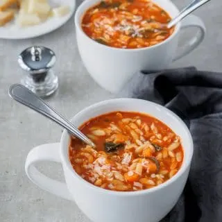 Tomato Orzo Soup served in large white mugs.