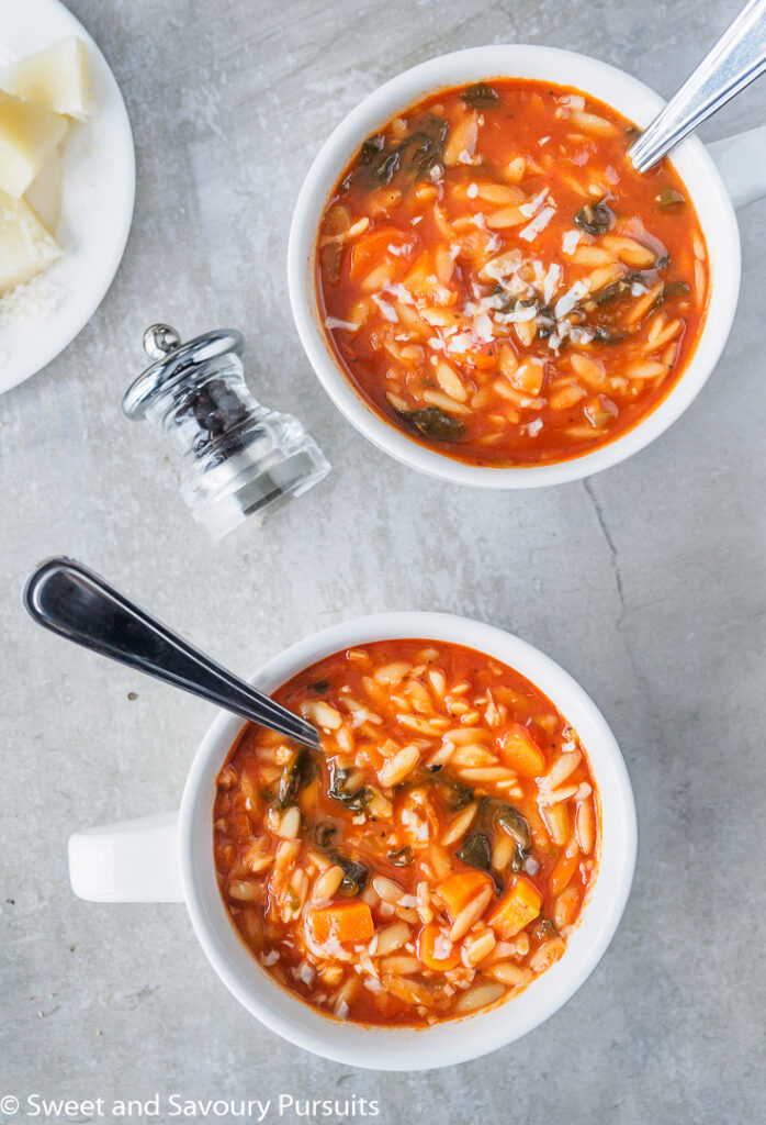 Tomato Orzo Soup served in large white mugs.