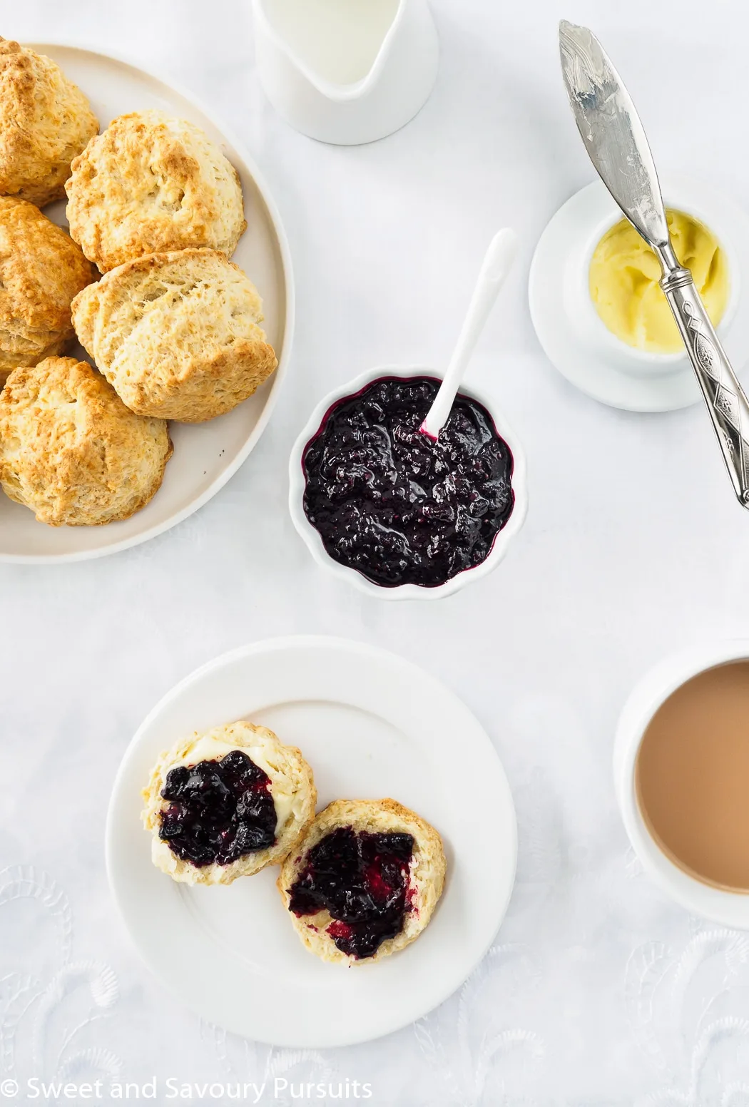 A dish of Irish Scones served with tea, butter and mixed berry jam.