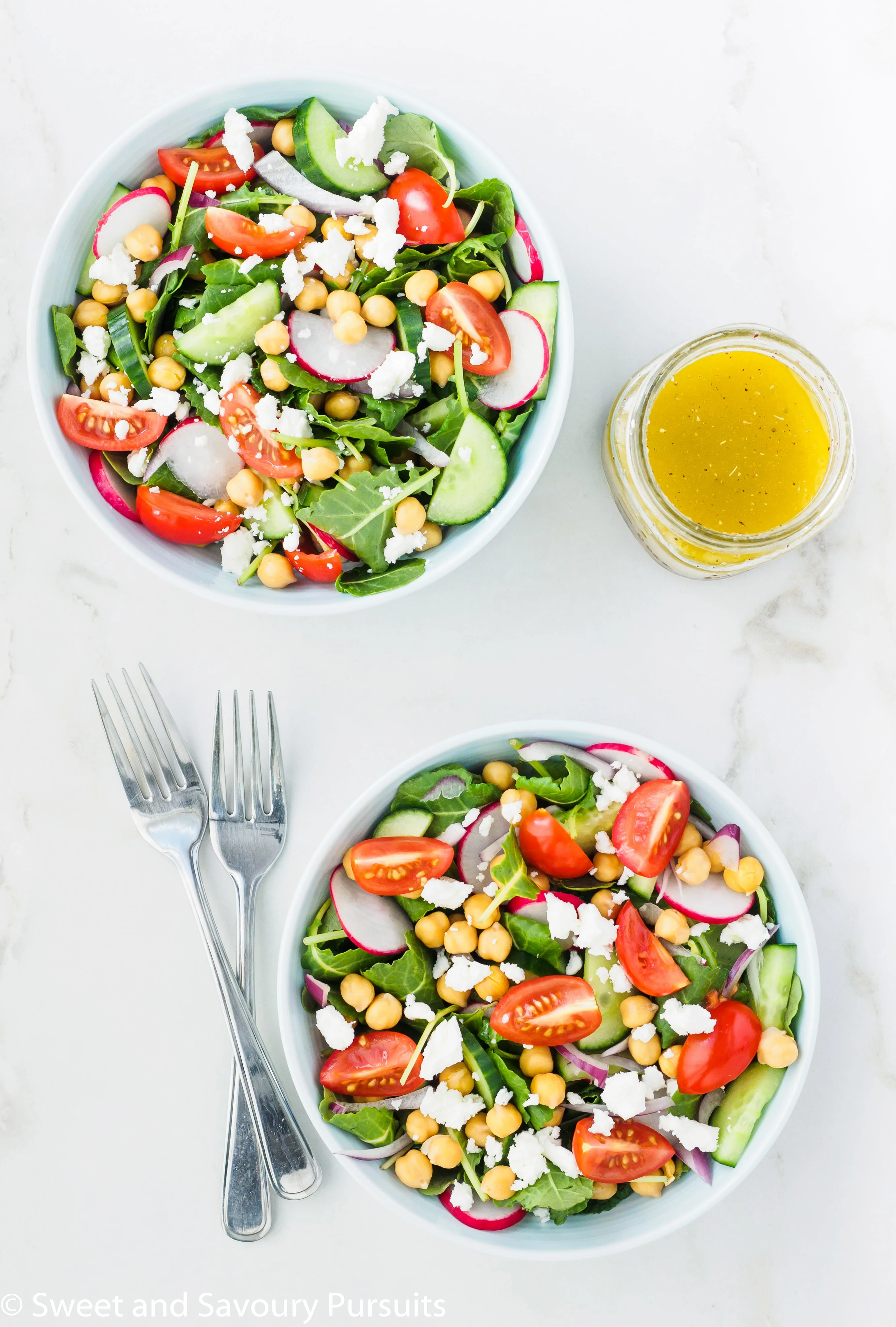 Mediterranean baby kale salad with chickpeas served with a lemon garlic dressing on the side.