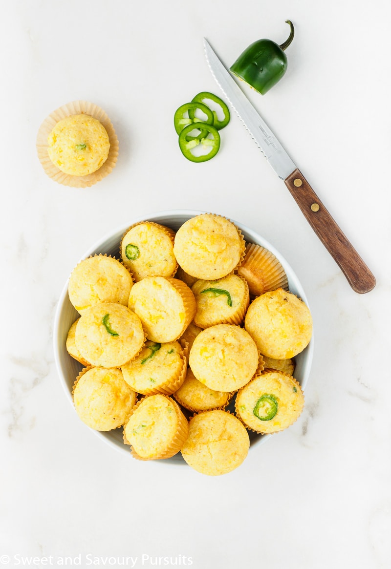 Freshly baked Mini Cornbread Muffins with corn and jalapeno in bowl.