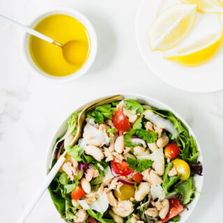One bowl of White Bean and Tuna Salad served with a lemon and olive oil dressing on the side.