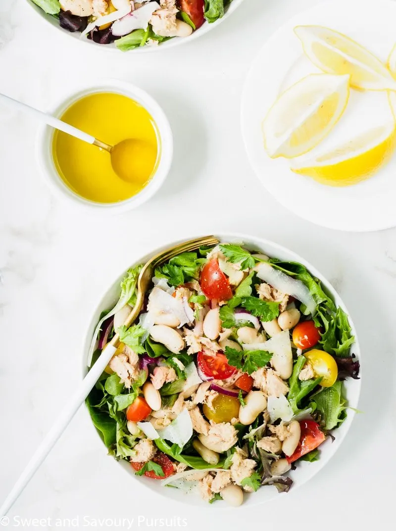 A bowl of White Bean and Tuna Salad served with a lemon and olive oil dressing on the side.