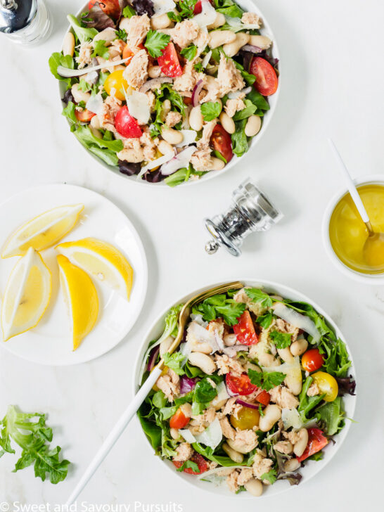 Two bowls of White Bean and Tuna Salad with lemon and olive oil dressing served on the side.