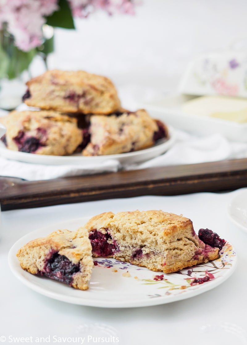 Close-up of a plate with a cut Blackberry scone.