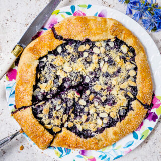 A rustic Blueberry Almond Crumble Galette on a serving plate.