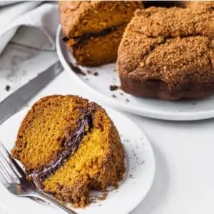 Slice of pumpkin chocolate bundt cake on white dish.