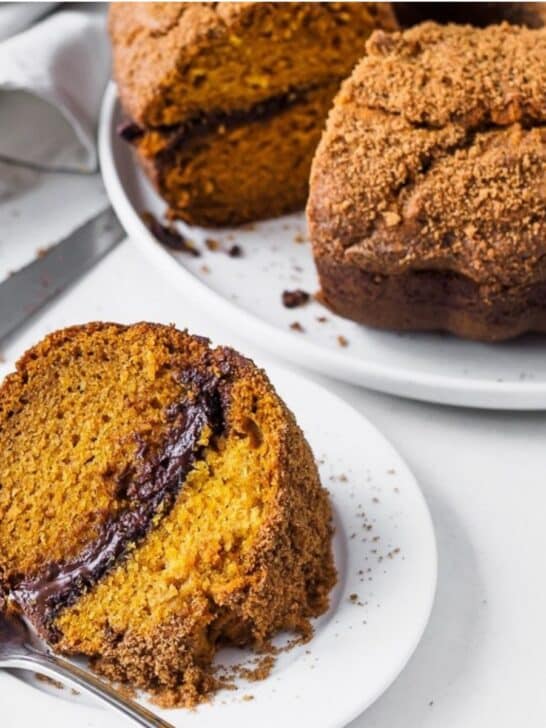 Slice of pumpkin chocolate bundt cake on white dish.