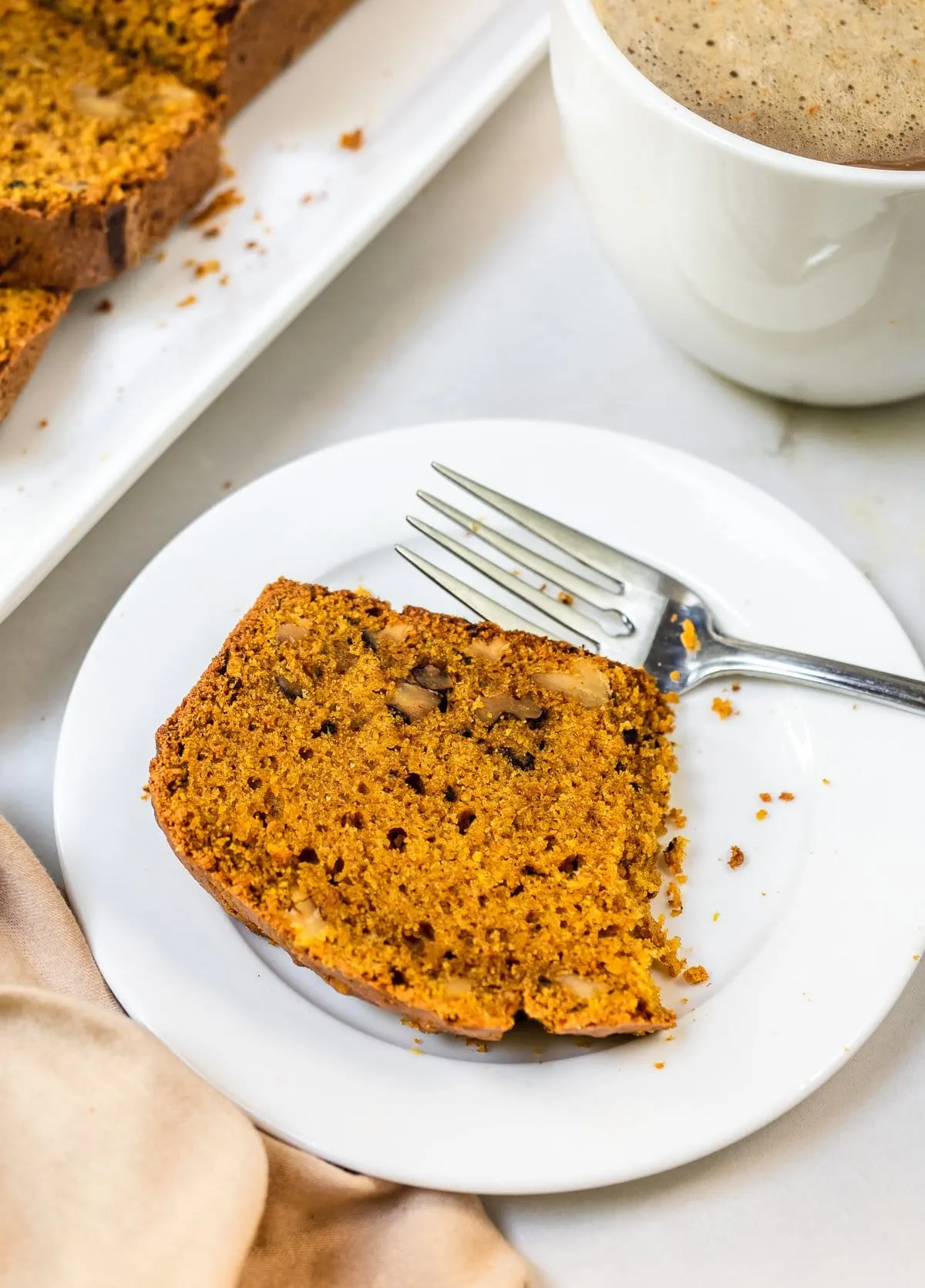 Partially eaten slice of spiced pumpkin loaf.