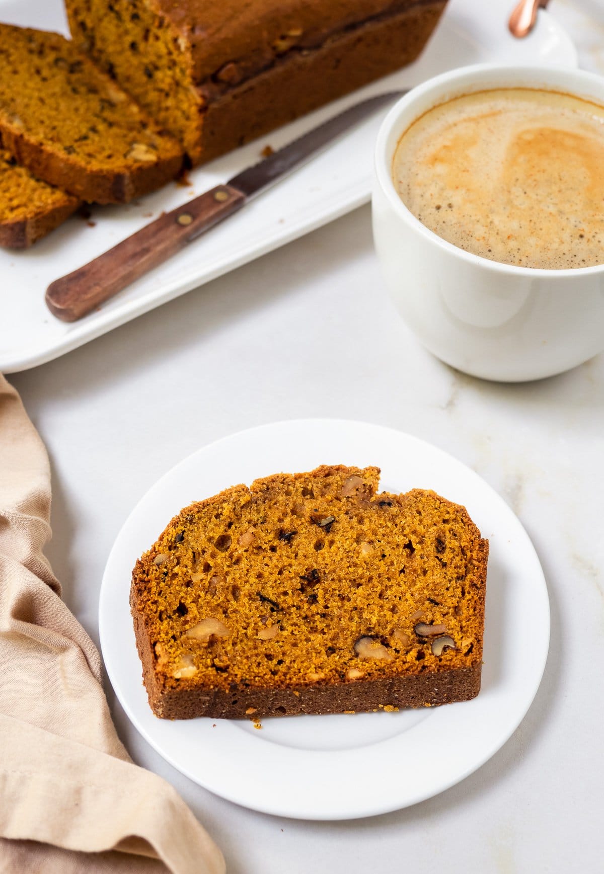 Plated slice of a pumpkin walnut bread.