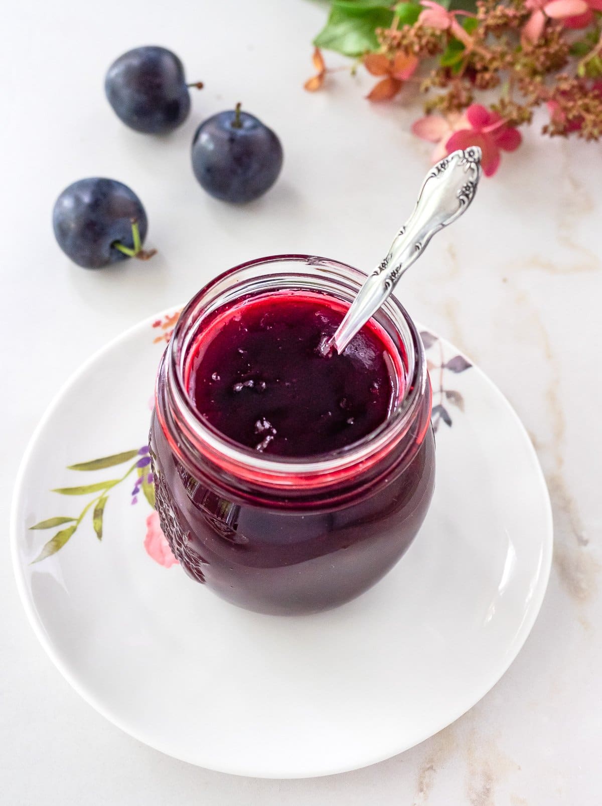 Homemade plum jam in small mason jar.