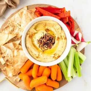 Platter of Caramelized Onion Hummus served with vegetable and pita chips.