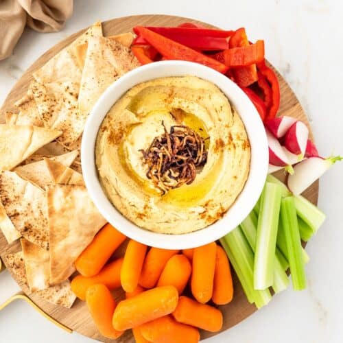 Platter of Caramelized Onion Hummus served with vegetable and pita chips.