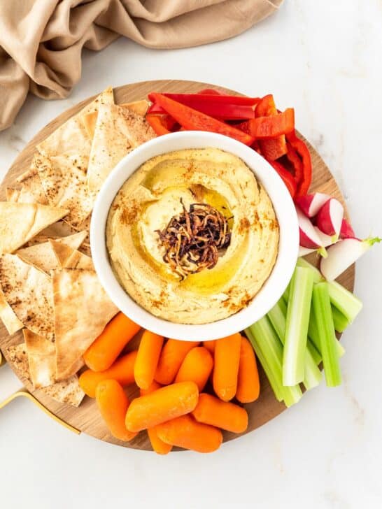 Platter of Caramelized Onion Hummus served with vegetable and pita chips.