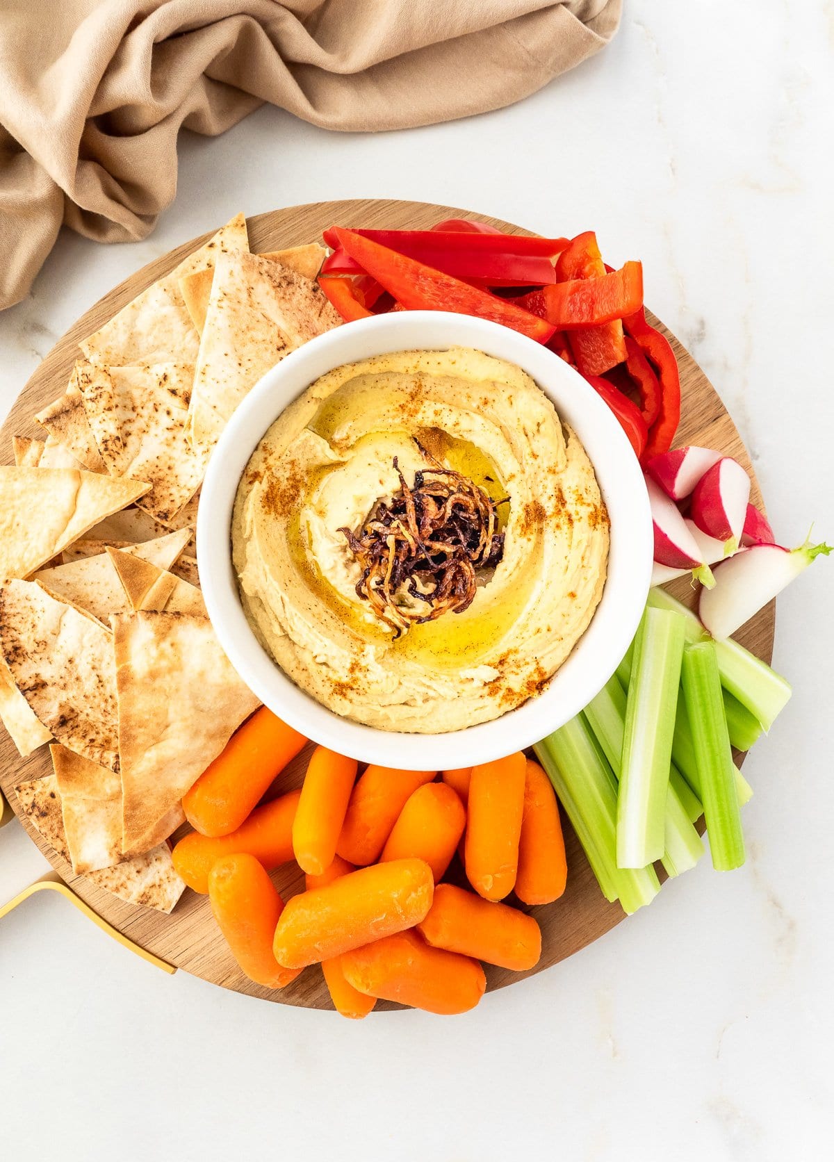 Platter of Caramelized Onion Hummus served with vegetable and pita chips.