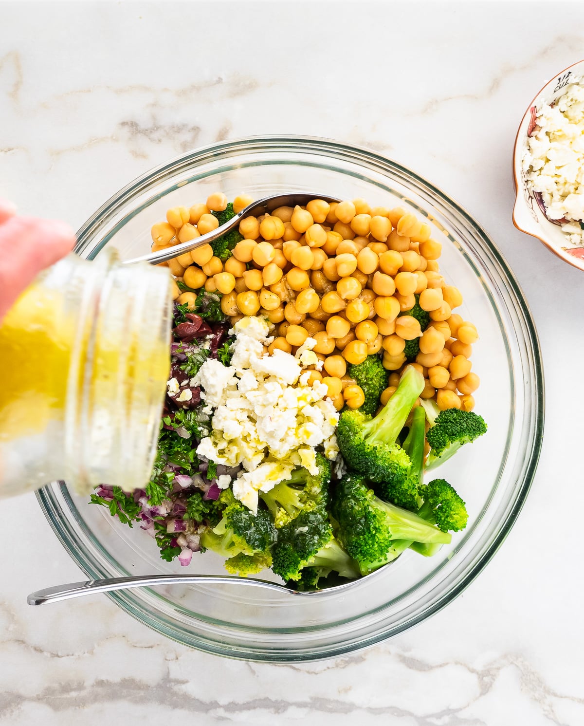 Dressing being poured over salad.