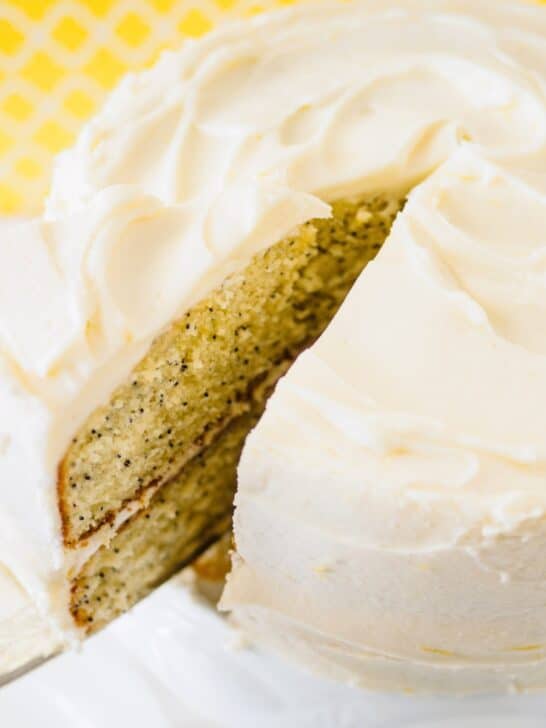 Lemon poppy seed cake with slice being removed.